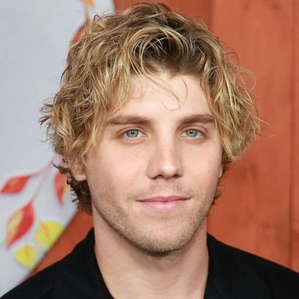 Messy Wavy Bro Flow hairstyle for oval face shape - men's medium wavy hair